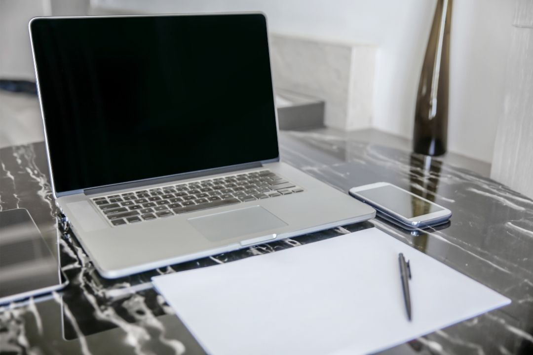 Gestão de equipes remotas: imagem mostra notebook com bloco de anotações ao lado.